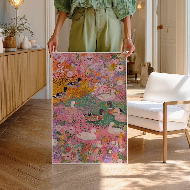 May include: A framed art print depicting a colourful floral scene with ducks. The artwork features a vibrant mix of pink, yellow, and green flowers, with several ducks dotted throughout. The ducks have white, brown, and black feathers.