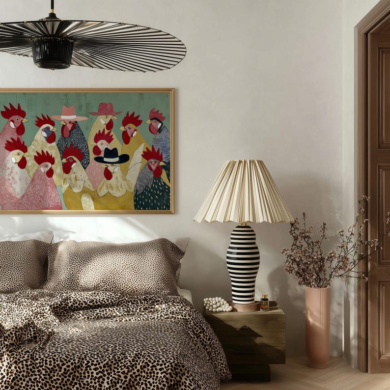 K&ouml;nnte beinhalten: Ein Schlafzimmer mit einem gerahmten Kunstwerk von H&auml;hnen mit H&uuml;ten, einem Bett mit Leopardenmuster-Bettw&auml;sche und einer Lampe mit schwarz-wei&szlig; gestreiftem Sockel. Eine Vase mit rosa Blumen steht auf einem Nachttisch aus Holz.