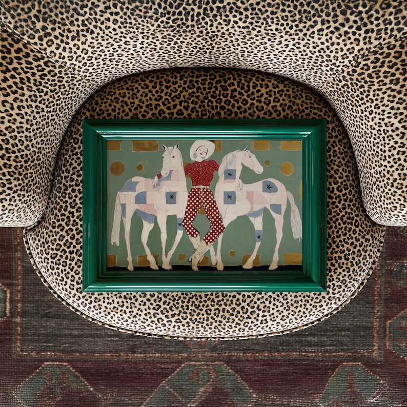 Modern western art print featuring a stylish cowgirl in a white hat and red polka dot outfit posed between two white patchwork horses. Soft sage green background with gold geometric accents and quilt-like horse patterns create a chic, editorial equestrian vibe. Perfect for contemporary western decor, ranch house interiors, cowgirl chic bedrooms, offices, and giftable horse lover wall art.