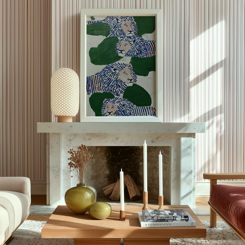 May include: A living room scene featuring a framed artwork with blue and white lions on a white marble mantel. A wooden coffee table holds candles, a vase, and books. A beige lamp and striped wallpaper complete the decor.