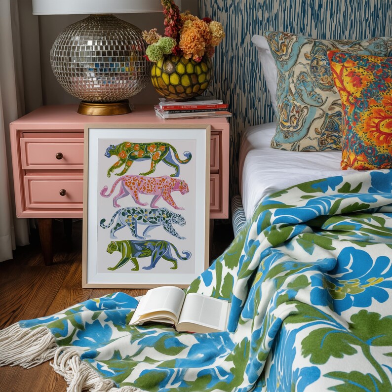 Four prowling leopards in vivid green, pink, sky-blue and indigo coats, each with whimsical floral patterns, stride across a cream backdrop. The bold dopamine palette enlivens living rooms, nurseries or eclectic gallery walls.