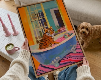 Könnte beinhalten: Ein gerahmtes rechteckiges Gemälde, das einen Tiger in einer blauen Badewanne mit Klauenfüßen zeigt. Der Hintergrund besteht aus einer leuchtend orangefarbenen Wand, einem gelben Türrahmen und einem rosa-violett gestreiften Boden.