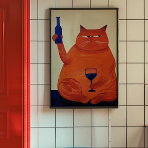 May include: A framed illustration of an orange cat holding a glass of red wine and a blue bottle. The cat is sitting on a blue background. The frame is black and the background is white tile.