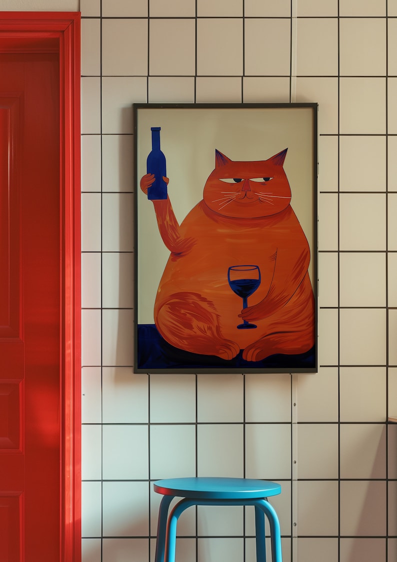 May include: A framed illustration of an orange cat holding a glass of red wine and a blue bottle. The cat is sitting on a blue background. The frame is black and the background is white tile.