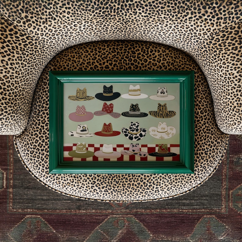 May include: A framed artwork featuring a collection of illustrated hats in various styles and colors. The hats are arranged on a light green background with a red and white checkered border. The frame is a vibrant green.