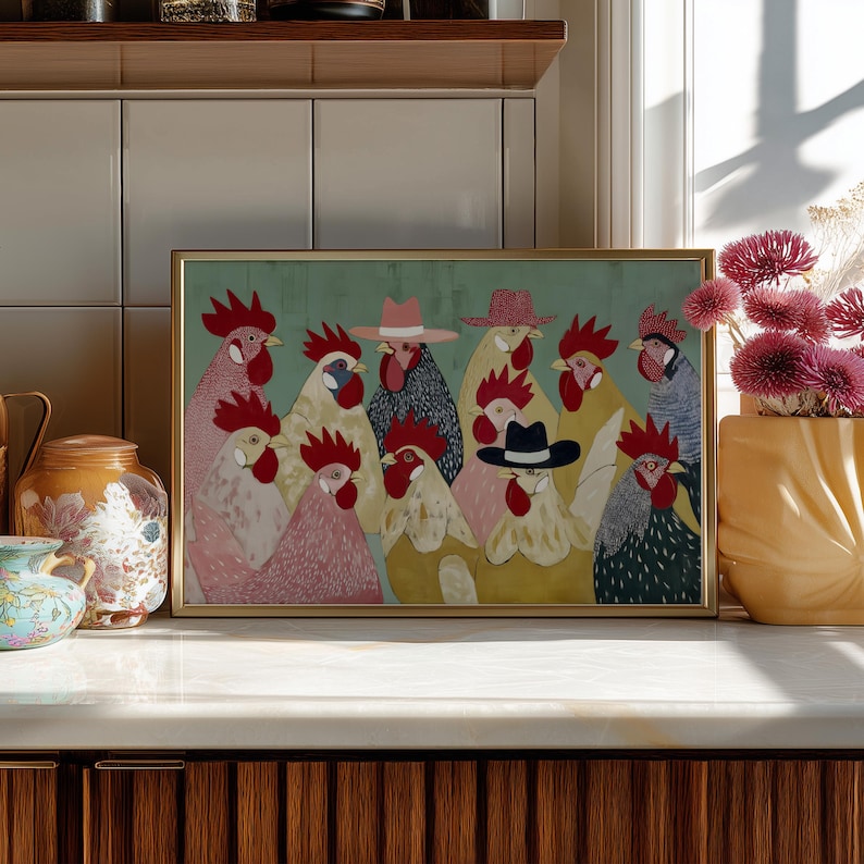 K&ouml;nnte beinhalten: Ein gerahmter Kunstdruck mit einer Gruppe stilisierter H&auml;hne, von denen einige H&uuml;te tragen. Die H&auml;hne sind in verschiedenen Farben gehalten, darunter Rosa, Gelb und Grau, vor einem gr&uuml;nen Hintergrund. Der Rahmen ist goldfarben.