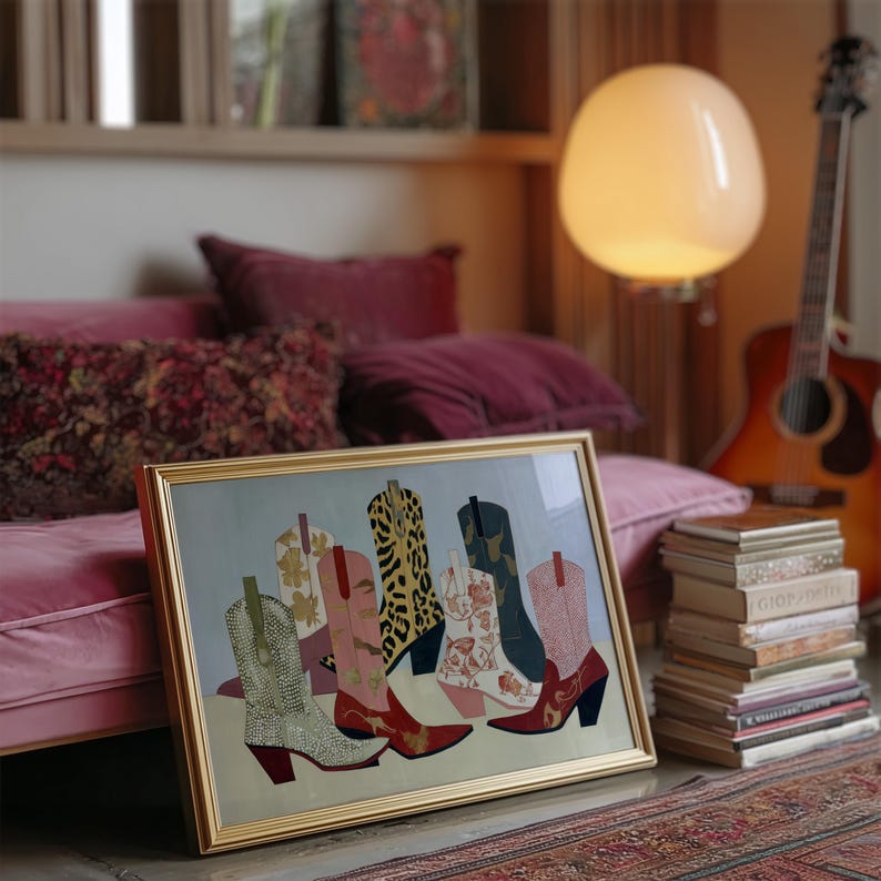 May include: A framed artwork featuring a collection of colorful cowboy boots. The boots showcase various patterns, including leopard print, floral designs, and solid colors. The artwork is set against a light blue background, with a gold frame.