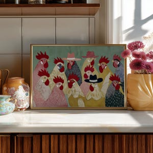 K&ouml;nnte beinhalten: Ein gerahmter Kunstdruck mit einer Gruppe stilisierter H&auml;hne mit H&uuml;ten. Die H&auml;hne sind in verschiedenen Farben dargestellt, darunter Rosa, Gelb und Grau, vor einem t&uuml;rkisgr&uuml;nen Hintergrund. Der Rahmen ist goldfarben.