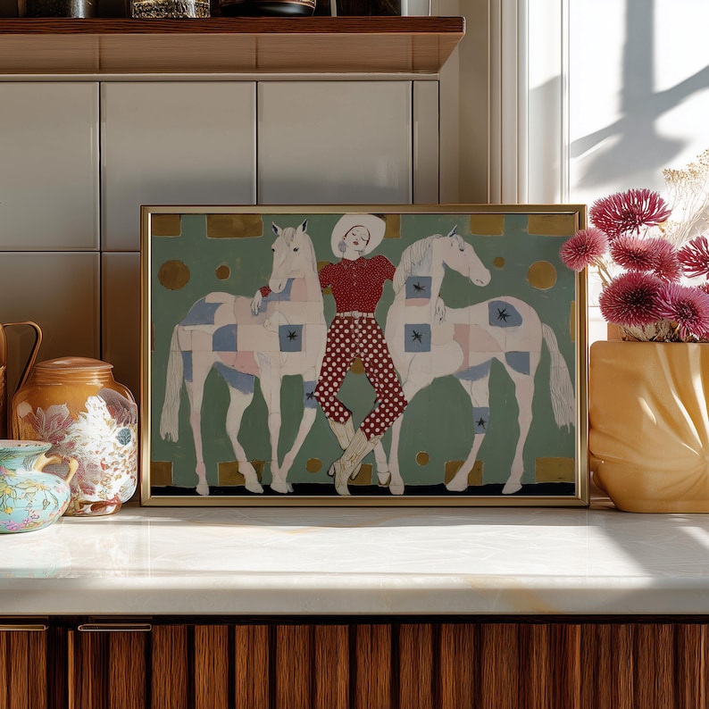 Modern western art print featuring a stylish cowgirl in a white hat and red polka dot outfit posed between two white patchwork horses. Soft sage green background with gold geometric accents and quilt-like horse patterns create a chic, editorial equestrian vibe. Perfect for contemporary western decor, ranch house interiors, cowgirl chic bedrooms, offices, and giftable horse lover wall art.