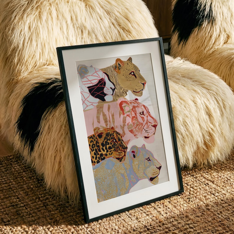 May include: A framed vertical art print featuring a stacked composition of four big cats. The top cat is tan, the second is pink, the third is a spotted leopard, and the bottom cat is light blue. The frame is thin and black with a white mat border.