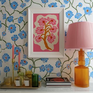 Flat-graphic illustration of a stylized orange tree trunk sprouting bright pink daisies on a cream blob shape against a vibrant pink background—cheerful, preppy and coquette-inspired.