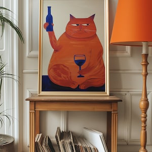 May include: A framed painting of an orange cat holding a glass of red wine and a blue bottle. The cat is sitting on a blue background. The painting is on a wooden shelf with a stack of vinyl records.