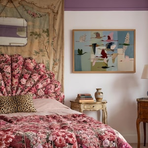 May include: A bedroom scene featuring a scalloped floral headboard in shades of pink and red, a leopard print pillow, and a quilted floral bedspread. A framed wall art piece depicts multiple birds in flight against a segmented blue background.