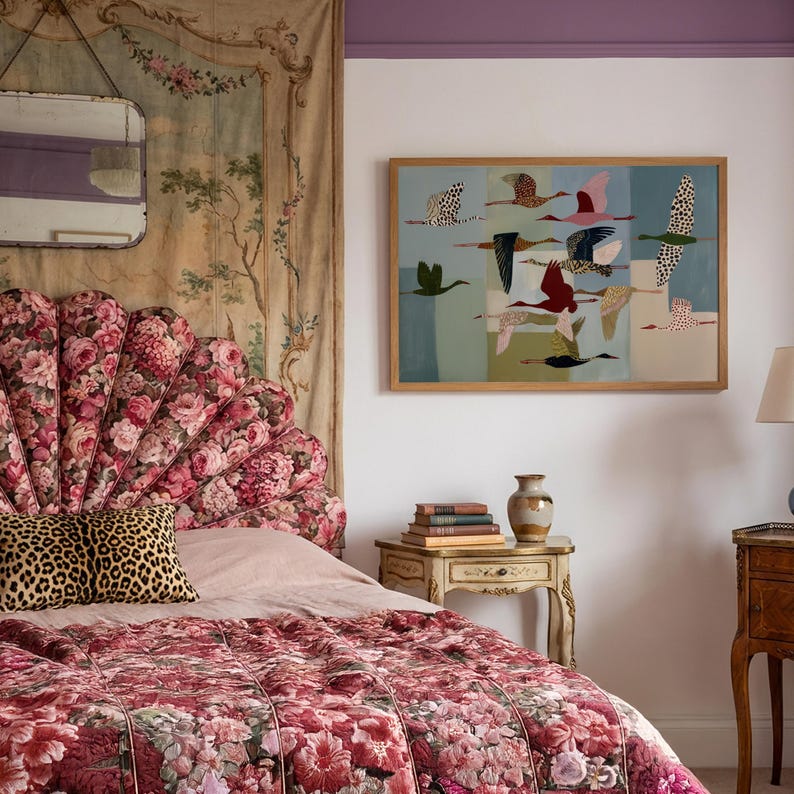 May include: A bedroom scene featuring a scalloped floral headboard in shades of pink and red, a leopard print pillow, and a quilted floral bedspread. A framed wall art piece depicts multiple birds in flight against a segmented blue background.