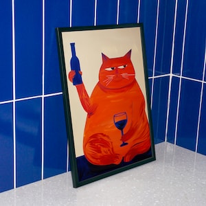 May include: A framed illustration of an orange cat holding a glass of red wine and a blue bottle. The cat has a sly expression on its face.