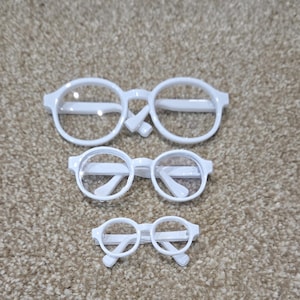 Okulary dla lalek z białego tworzywa sztucznego w różnych rozmiarach, szerokość ok. 9 cm/90 mm, 6,5 cm/65 mm, 4,5 cm/45 mm
