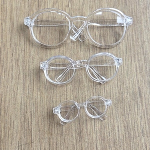 Gafas de plástico con montura transparente para muñecas (varios tamaños: 90 mm/9 cm, 65 mm/6,5 cm y 45 mm/4,5 cm de ancho)