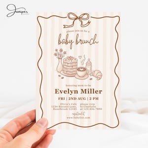 May include: Baby brunch invitation with a brown border and vertical striped background. The invitation features a bow, the text "baby brunch", and illustrations of food items like pancakes, coffee, and a croissant. The invitation is for Evelyn Miller.