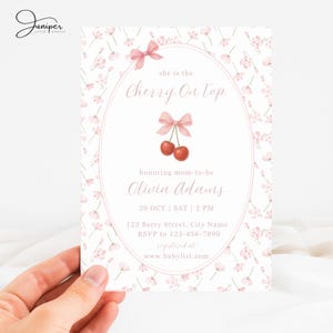 May include: A baby shower invitation with a floral design and the text "she is the Cherry On Top". The invitation features a pink bow and cherry graphic. The invitation includes the date, time, location, and RSVP information.