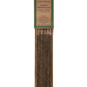 May include: A pack of 10 natural patchouli leaf incense sticks. The packaging is brown with green text that reads "AUROSHIKHA Natural Patchouli Leaves Relaxing and Calming Rich, woody, earthy, slightly balsamic note Natural Leaf Incense This fragrance is pleasing recommended for stress relief and is a natural mosquito repellent 10 Sticks 100% Natural ingredients".