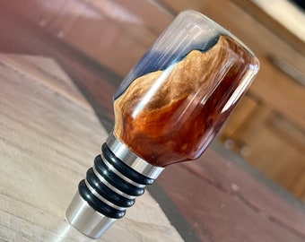 Handmade stainless bottle stopper made with burl wood and colored translucent resin.