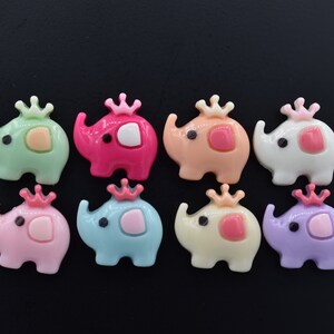 May include: Eight colourful plastic elephant figurines with crowns, each in a different colour: green, pink, orange, white, blue, yellow, purple, and light pink.