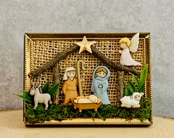 Mini Nativity in repurposed 2 1/2”x 3 1/2” gold frame with burlap background.