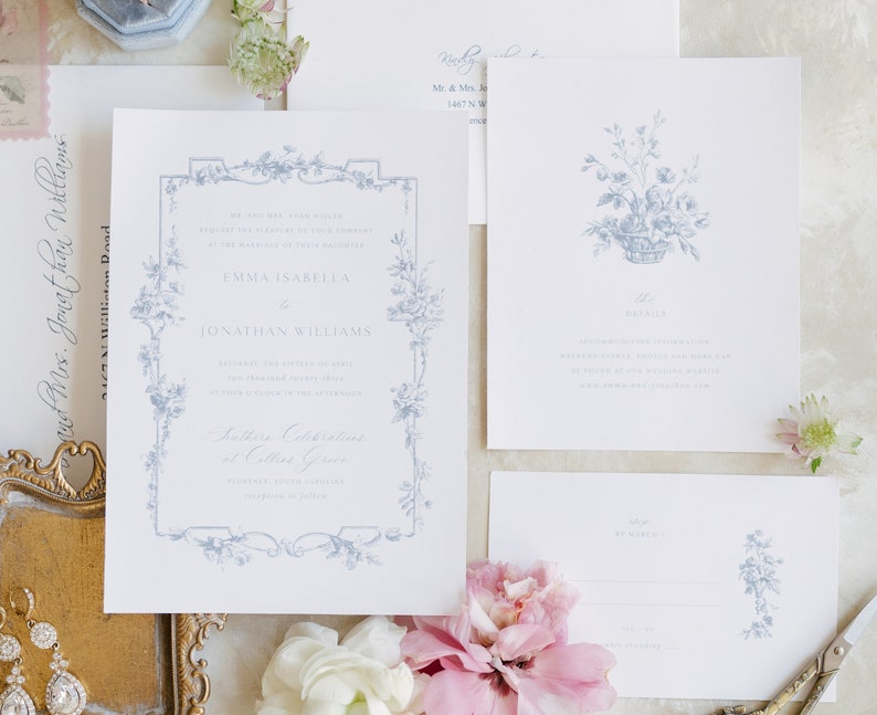 May include: A wedding invitation suite with a blue and white floral design. The invitation features a decorative border with a floral motif and the text "Emma Isabella to Jonathan Williams". The RSVP card features a floral design and the text "RSVP by March 1".