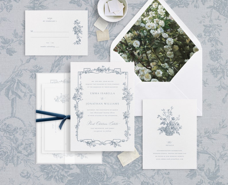 May include: A wedding invitation suite with a floral design. The invitation card features a blue floral border and the text "Emma Isabella & Jonathan Williams". The RSVP card features a blue floral design and the text "RSVP by February 1". The details card features a blue floral design and the text "The Details".