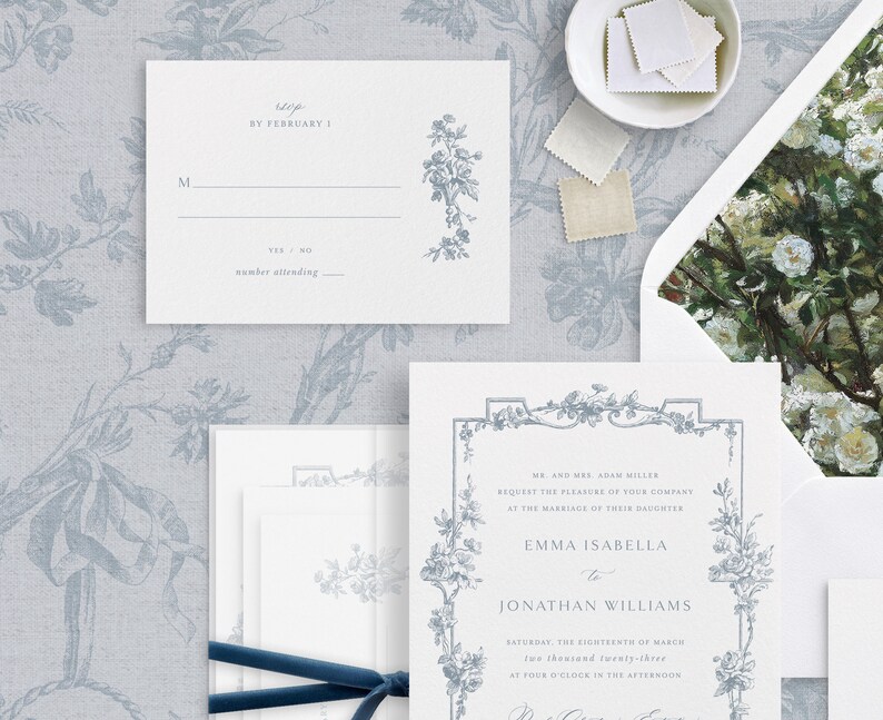 May include: A white wedding invitation with a blue floral border. The invitation reads "Mr. and Mrs. Adam Miller request the pleasure of your company at the marriage of their daughter Emma Isabella to Jonathan Williams Saturday, the eighteenth of March two thousand twenty-three at four o'clock in the afternoon."