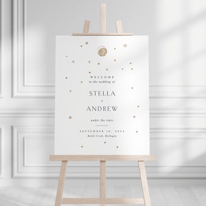 May include: A white wedding welcome sign with gold foil stars and a moon design. The sign reads "Welcome to the wedding of Stella + Andrew under the stars September 16, 2024 Battle Creek, Michigan".