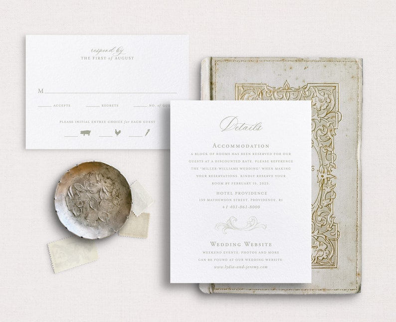 May include: A white RSVP card with a grey border and text that reads "responded by THE FIRST of AUGUST". The card has a section for the guest's name, a checkbox for accepting or declining the invitation, and a section for the number of guests. There are three icons below the checkboxes: a pig, a chicken, and a fork. The card is on a white background.