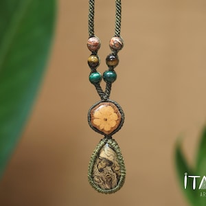 May include: A macrame necklace featuring a green cord, two pairs of round beads in brown, tiger eye, and teal, a circular tan wooden pendant with a carved flower, and a teardrop-shaped pendant with a marbled brown and tan pattern.