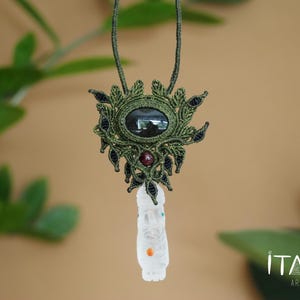 May include: A green and black macrame necklace with a dark gemstone pendant and a white carved stone charm. The necklace is accented with red and blue beads.