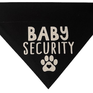 May include: Black dog bandana with white text that says "BABY SECURITY" and a white paw print with a heart in the centre.