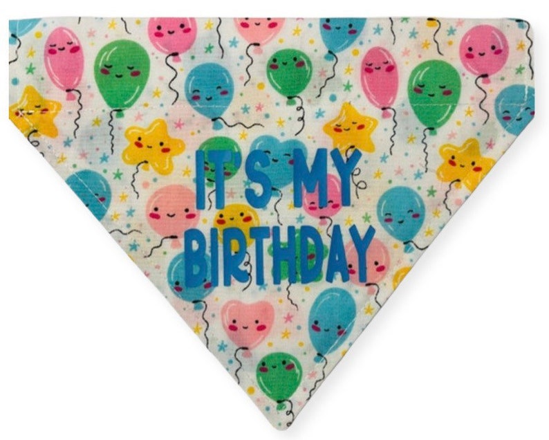 May include: White fabric dog bandana with a colorful balloon pattern and the text "It's My Birthday" in blue.