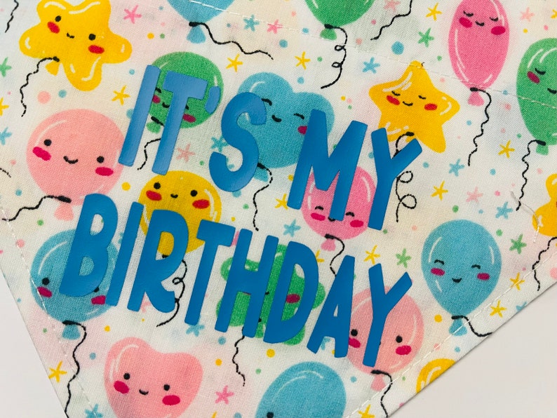 May include: White fabric with a blue and yellow pattern of balloons and stars. The text "It's My Birthday" is written in blue.