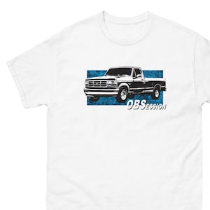 May include: White t-shirt with a black and white illustration of a pickup truck on a blue background. The text "OBSESSION" is below the truck.
