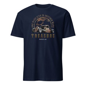 May include: A navy blue t-shirt with a distressed, rusty-colored skull and hot rod graphic. The graphic is surrounded by a circle with the text "One Man's Junk Is Another Man's Treasure" and the website "Mo'sHdz.com".