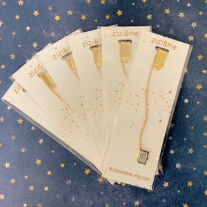 May include: Six gold bookmark chains with a small gold book charm at the end. The chains are packaged on white cards with the text "zizi&me" and "ziziandme.etsy.com".