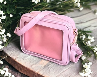 De Hollingworth Crossbody, luxe ITA-tas van veganistisch leer met doorzichtig vinylvenster en inzetstuk voor pin-display. Pinverzamelaars dromen van een cadeau!