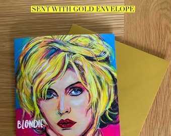 May include: A colorful greeting card featuring a portrait of Blondie, a famous singer, with the text "BLONDIE" printed on the card. The card is 6 inches by 6 inches and comes with a gold envelope.
