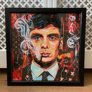 Puede incluir: Una pintura enmarcada de un hombre con cabello oscuro y un traje negro. Est&aacute; fumando un cigarrillo y tiene una expresi&oacute;n seria en su rostro. El fondo es un patr&oacute;n rojo y negro con el logotipo de Louis Vuitton.