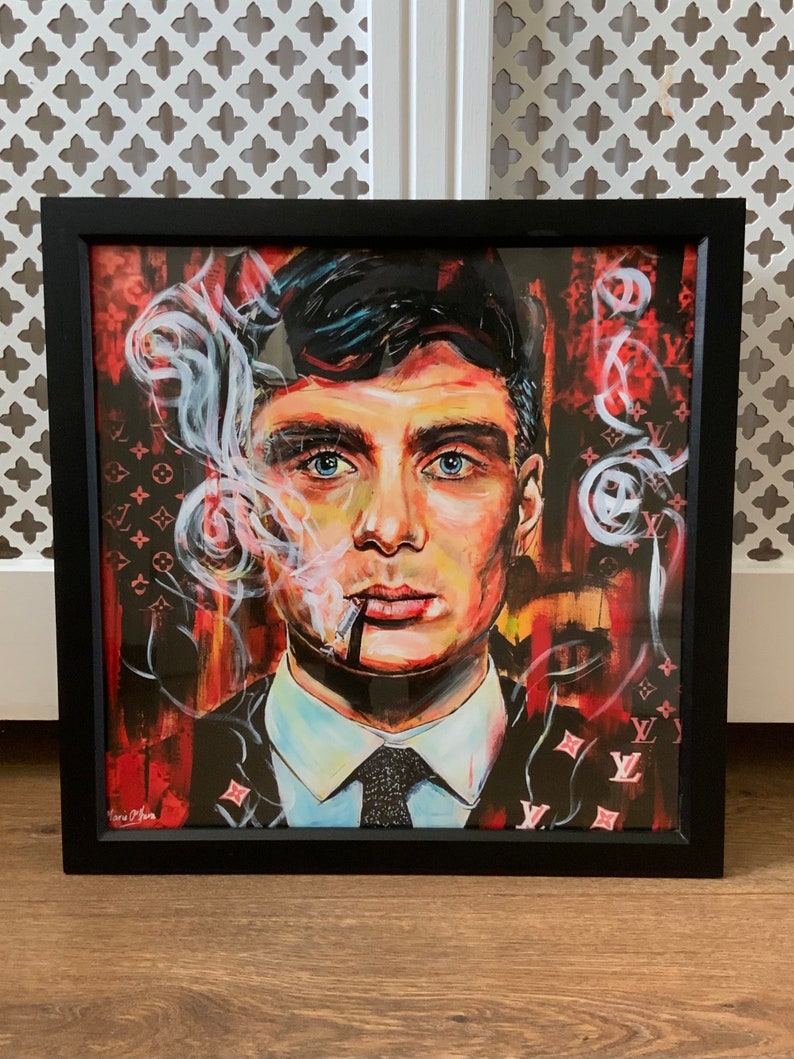 Puede incluir: Una pintura enmarcada de un hombre con cabello oscuro y un traje negro. Est&aacute; fumando un cigarrillo y tiene una expresi&oacute;n seria en su rostro. El fondo es un patr&oacute;n rojo y negro con el logotipo de Louis Vuitton.