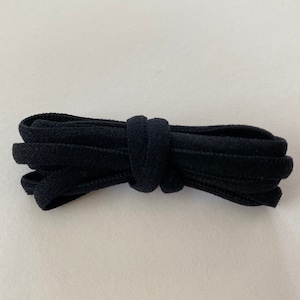 Pode incluir: Cadar&ccedil;o el&aacute;stico preto para sapatos, dobrado e amarrado.