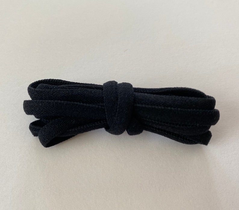 Pode incluir: Cadar&ccedil;o el&aacute;stico preto para sapatos, dobrado e amarrado.