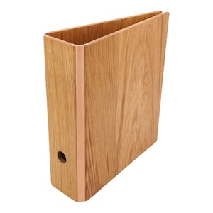 May include: A wooden binder with a copper colored edge. The binder is made of natural wood with a grain pattern.