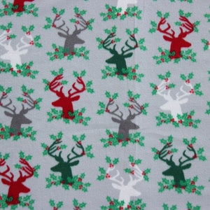 May include: A gray fabric with a repeating pattern of red, green, gray, and white reindeer with holly leaves and red berries.