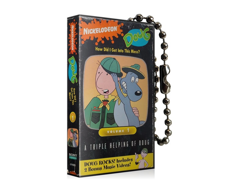 May include: A black and grey Doug VHS tape featuring the Nickelodeon logo and the title "How Did I Get Into This Mess?". The tape shows cartoon characters and text that reads "Volume 1" and "Doug Rocks! Includes 2 Bonus Music Videos!"