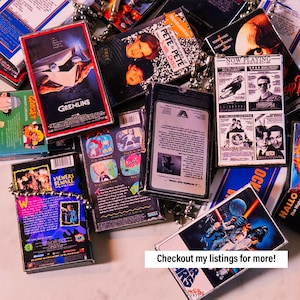 May include: A collection of vintage VHS tapes featuring various movie titles, including "Gremlins", "The Adventures of Pete & Pete", "Ghost Catchers", "Now Playing", and "Star Wars". The tapes are arranged in a pile and some are partially visible. The tapes are all in various colours and have different designs.